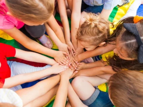 Kinder legen ihre Hände zusammen als Zeichen der Gemeinschaft